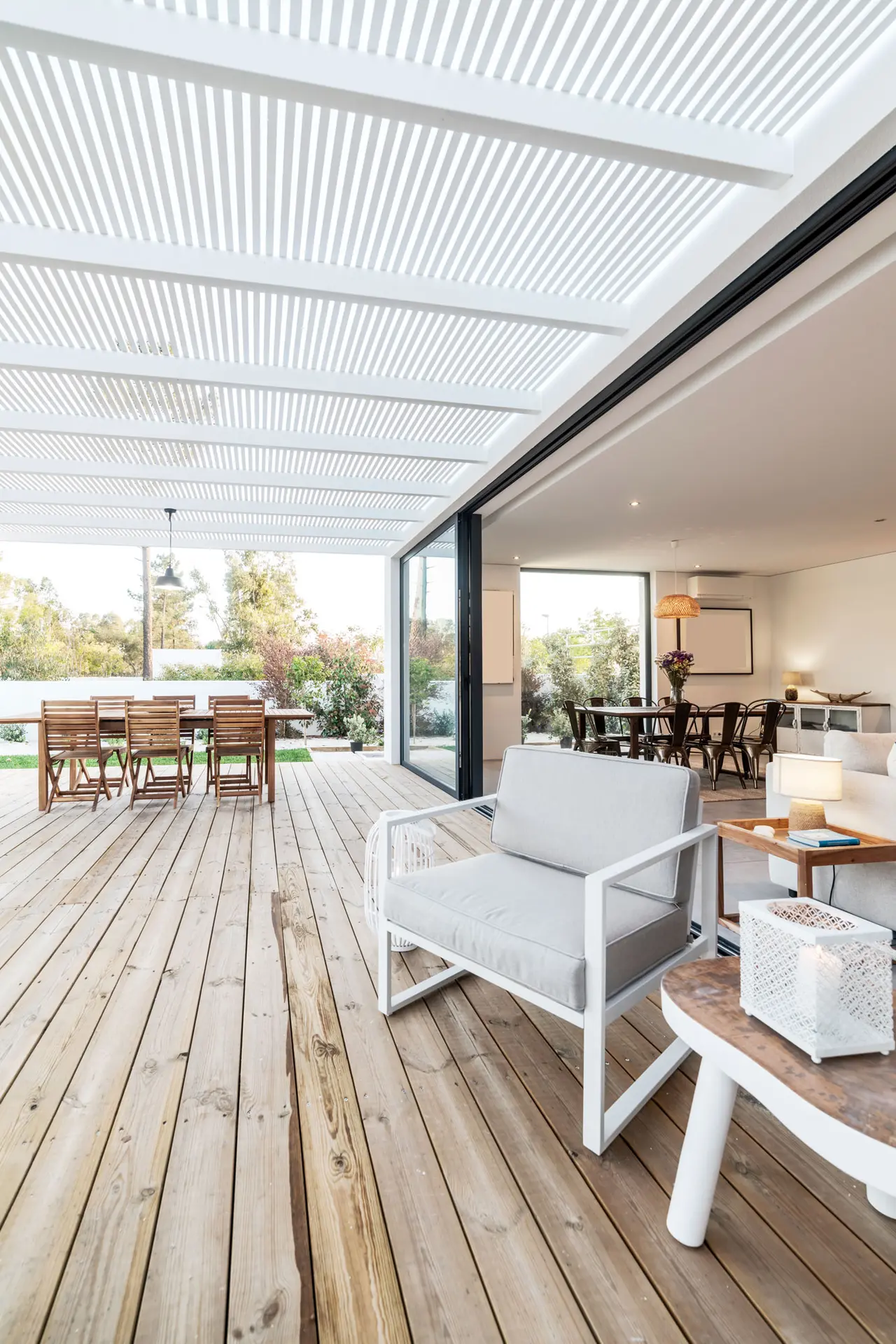Terrasse mit Holzboden unter der Pergola